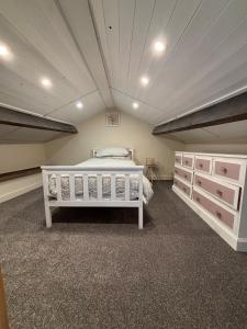 a bedroom with a white bed and a ceiling at The old surgery in Rhymney