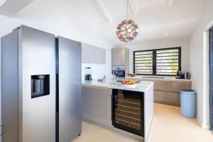 a large kitchen with a refrigerator and a counter at Villa El Rincon 637 - Coral Estate in Willibrordus