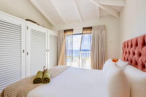 a bedroom with a white bed with a view of the ocean at Villa El Rincon 637 - Coral Estate in Willibrordus