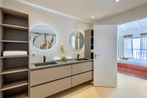 a bathroom with a double sink and two mirrors at Villa El Rincon 637 - Coral Estate in Willibrordus +9 photos