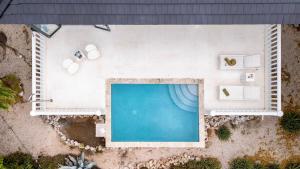 an overhead view of a swimming pool with chairs and tables at Villa El Rincon 637 - Coral Estate in Willibrordus