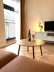 a living room with a table and two wine glasses at Apartamenty Staszica in Bielsko-Biała