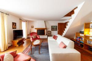 a living room with a white couch and a tv at Ferienhaus Grundschera Engadin in Brail