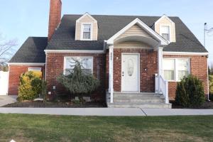 a red brick house with a white door at An Apartment for You to Relax - B in Uniondale