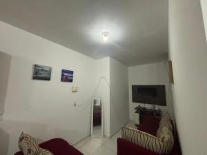 a living room with two chairs and a television at Apartamento in Maragogi
