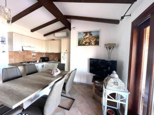 a kitchen and dining room with a table and a television at Villa La Dolce Vista & Private hydro pool in Costa Paradiso