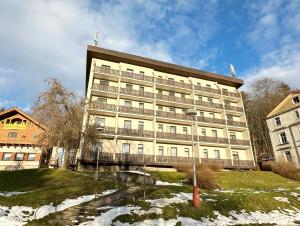 a large building with snow in front of it at Réva in Janske Lazne