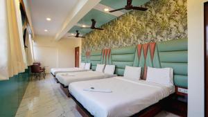 a row of beds in a hotel room at Hotel Balaji Residency Dombivali in Dombivli