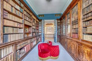 a red chair in a library with books at Château Optical Center in Nieuil