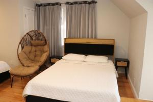 a bedroom with a bed and a chair at An Apartment for You to Relax - B in Uniondale