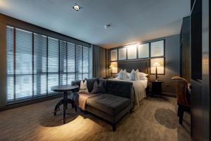 a bedroom with a bed and a couch and a table at Dakota Glasgow in Glasgow
