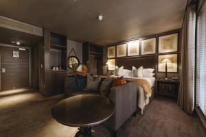 a bedroom with a bed and a couch and a table at Dakota Glasgow in Glasgow