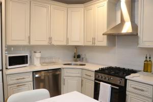 a kitchen with white cabinets and a stove top oven at An Apartment for You to Relax - B in Uniondale