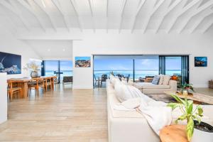 a living room with white furniture and a view of the ocean at Villa View in Stompneusbaai