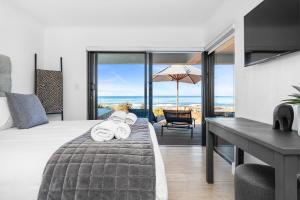 a bedroom with a bed and a desk with a view of the ocean at Villa View in Stompneusbaai +84 photos