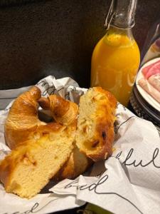 a plate of pastries and bread with a bottle of orange juice at Tiny House Ô Secret du Wérihay in Spa