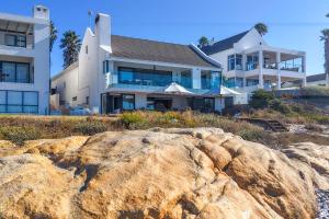 a house on the beach with a large rock at Villa View in Stompneusbaai