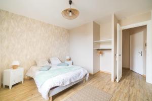 a bedroom with a bed with blue pillows at Le Petit Vals - Proche Casino in Vals-les-Bains
