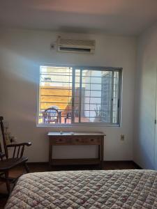 a bedroom with a bed and a window with a desk at La Pinta Càlida casa en Malvìn con cochera in Montevideo