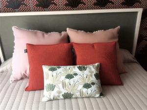 a group of pillows sitting on top of a bed at L'Instant des Hôtes in Combrit