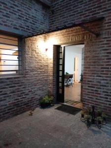 a brick wall with a door open to a room at La Pinta Càlida casa en Malvìn con cochera in Montevideo