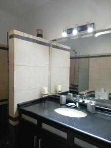 a bathroom with a sink and a large mirror at La Pinta Càlida casa en Malvìn con cochera in Montevideo +28 photos