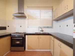 a kitchen with a sink and a stove top oven at La Pinta Càlida casa en Malvìn con cochera in Montevideo