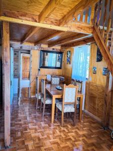 a dining room with a wooden table and chairs at Cabaña Santa Amelia Antuco Pet Friendly in Peluca