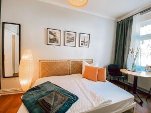 a bedroom with a bed with orange pillows and a table at BetterBeds City - Apartments - Zentral - Smart TV - Küche - WLAN in Brandenburg an der Havel