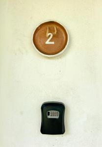 a clock on the side of a wall with a remote control at Pousada Jardim da Praça in Caraíva