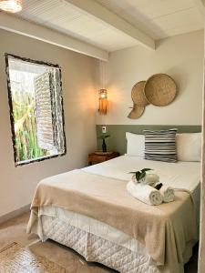 a bedroom with a bed with towels on it at Pousada Jardim da Praça in Caraíva