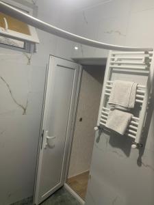 a bathroom with a towel rack and a mirror at Skyview House Tbilisi in Tbilisi City