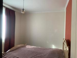 a bedroom with a bed and a curtain and a window at Skyview House Tbilisi in Tbilisi City +1 photo