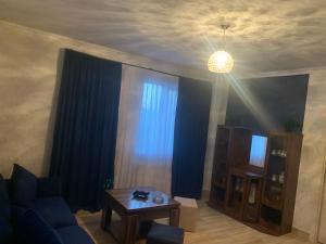 a living room with a blue couch and a table at Skyview House Tbilisi in Tbilisi City