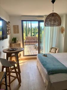 a bedroom with a bed and a table and a patio at Studio Nuitée en Provence 2 in Aix-en-Provence +54 photos