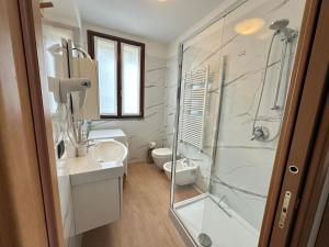 a bathroom with a shower and a sink and a toilet at Like Heaven Argegno Pool & Lake View in Argegno +10 photos