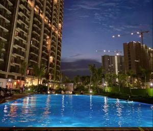 a large blue swimming pool in a city at night at Sky House BSD Apartment by Casanova in Cilenggang