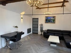 a living room with a black couch and a table at Sandstone Grange in Albrighton
