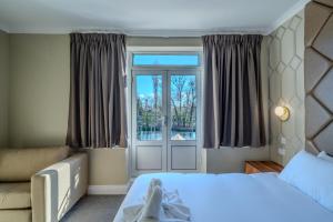 a bedroom with a bed and a window at Uno Thames Hotel -Reopened Brand New Again -FREE PARKING in Maidenhead +41 photos