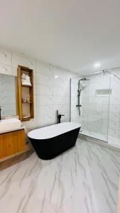 a large bathroom with a tub and a shower at Feliza Hotel and Suites in Abeokuta