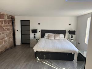 a bedroom with a large bed with two night stands at Sandstone Grange in Albrighton