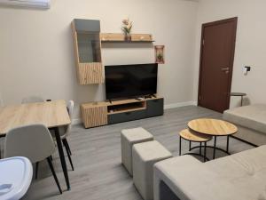 a living room with a television and a table and chairs at Matilda apartment in Fier