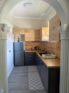 a kitchen with wooden cabinets and a blue refrigerator at Matilda apartment in Fier