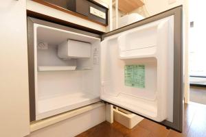 an empty refrigerator with its door open in a kitchen at sakura 601 in Tokyo