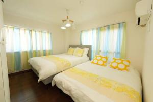 two beds in a small room with windows at sakura 601 in Tokyo