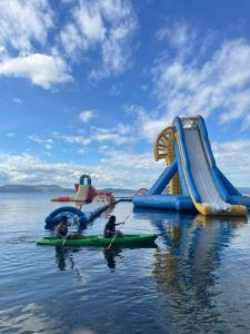 two people in kayaks in front of a water slide at Club Balai Isabel Front Taal Lake & Volcano View in Talisay
