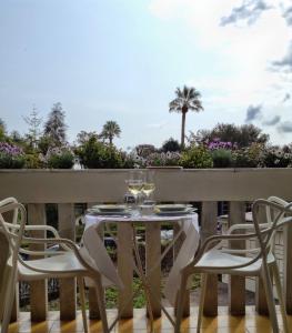 een tafel en stoelen op een balkon met een palmboom bij Casamati Flexyrent in Rapallo