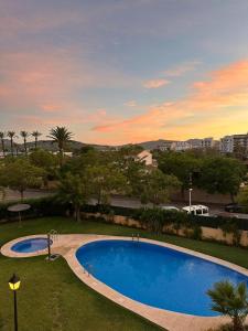 a swimming pool in a yard with a sunset at BiBi House in Jávea