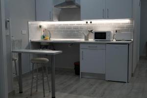 a kitchen with a sink and a counter with stools at Apartamentos Las trece llaves in Mérida +53 photos