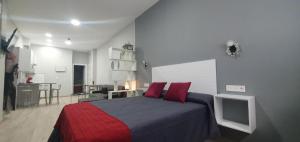a bedroom with a bed with red pillows at Apartamentos Las trece llaves in Mérida